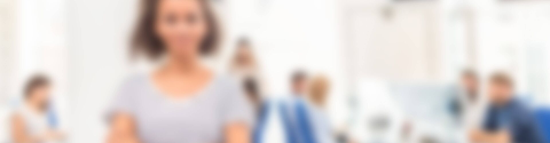 Mitarbeiterin steht in einem Großraumbüro